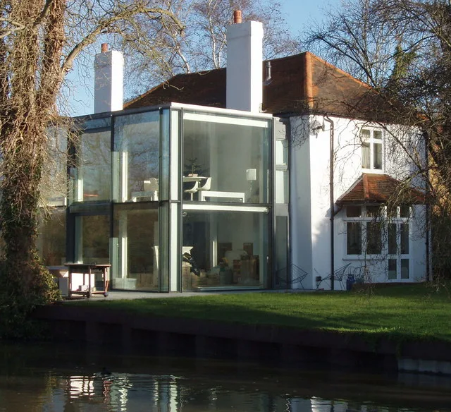 A glazed addition beside a traditional brick home
