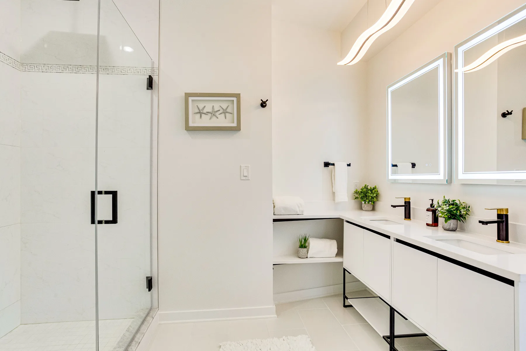 A bright bathroom with a walk-in shower and double vanity