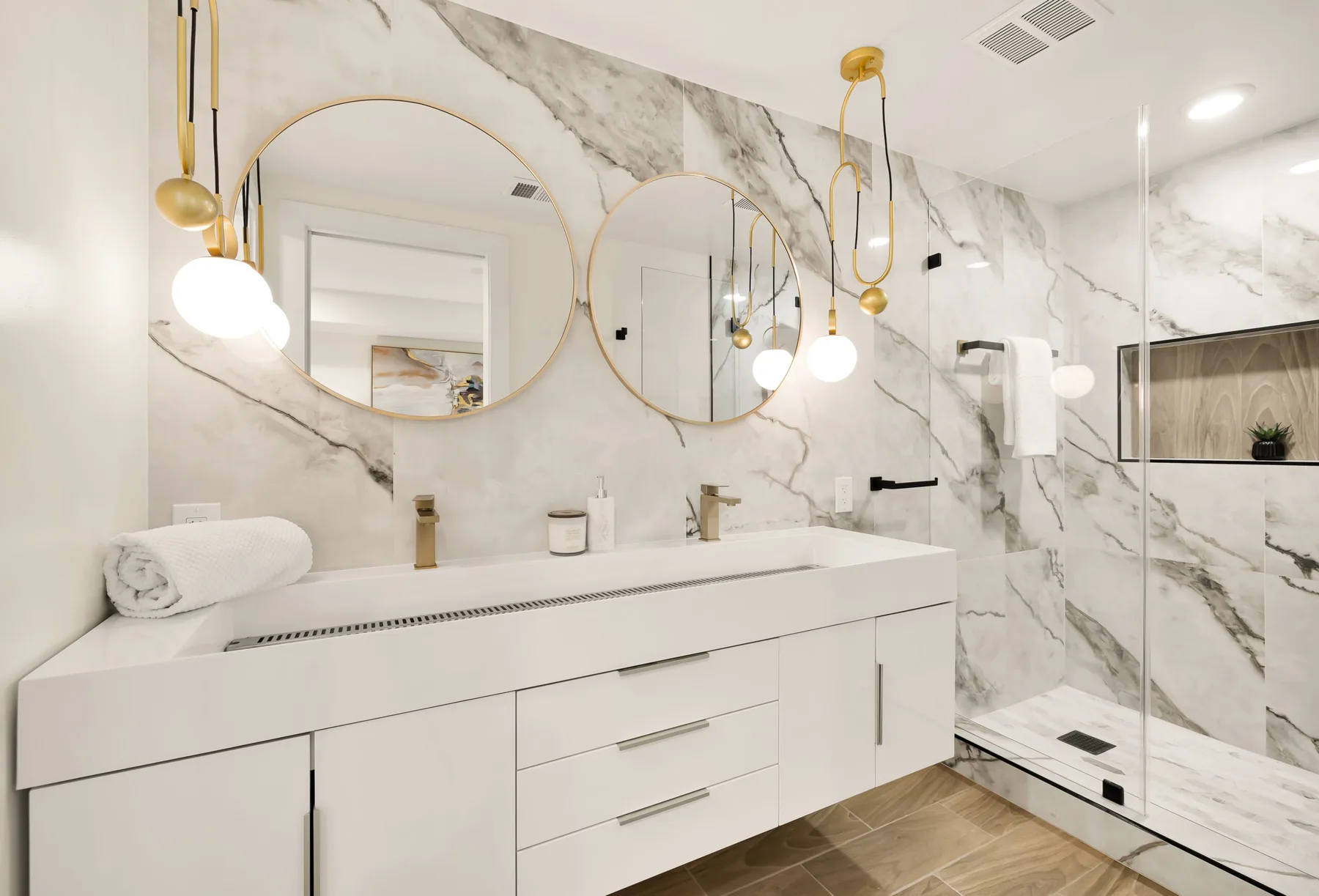A bathroom with arched mirrors and a marble shower