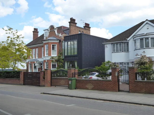 A contemporary dark-clad addition connecting traditional homes